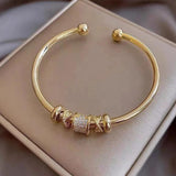 Bracciale regolabile con pendenti dorati